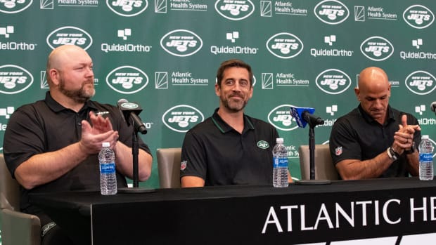 Jets' general manager Joe Douglas (far left) claps during Aaron Rodgers' introductory press conference